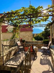 eine Terrasse mit Stühlen und einer Pergola in der Unterkunft Old town house with private garden in Budva