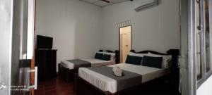 a bedroom with two beds and a television at Hotel Villa Ángel in Neiva +18 photos
