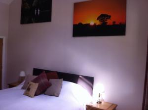 1 dormitorio con 1 cama y una foto en la pared en The Cholmeley Arms, en Burton Coggles