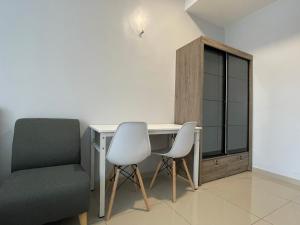 a room with a desk and two chairs and a window at Reno Hotel Ipoh in Ipoh