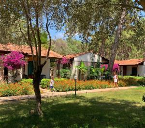 two children walking through a garden with flowers at Denizati Holiday Village in Gumuldur