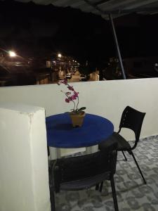 a blue table and a chair on a balcony at night at Hospedaria in Recife