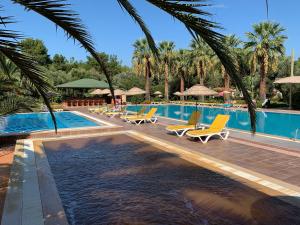 a swimming pool with lounge chairs and a resort at Denizati Holiday Village in Gumuldur