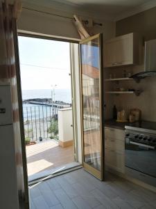 a kitchen with a sliding glass door leading to a balcony at La casa in piazzetta in Riposto