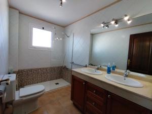 La salle de bains est pourvue de 2 lavabos, de toilettes et d'un miroir. dans l'établissement Mandala, à Tías