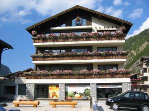 a building with a balcony with flowers on it at Sportina in Saas-Grund