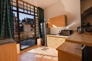 a kitchen with a large window with a view of a patio at La Terrasse du Thiou - Location in Annecy