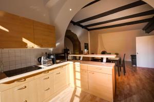 a kitchen with wooden cabinets and a table in it at La Terrasse du Thiou - Location in Annecy
