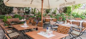 um restaurante com mesas e cadeiras de madeira e um guarda-sol em Landhotel Gasthof Huber em Merching
