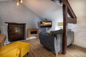 a living room with a couch and a tv at The Granary in Bryn-crug