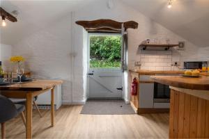 a kitchen with a door leading into a kitchen with a table at The Granary in Bryn-crug