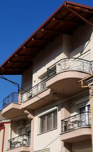 a white building with balconies and a blue sky at Iliana's house in Naousa Imathias