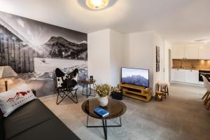 ein Wohnzimmer mit einem Sofa und einem TV in der Unterkunft Alpin Supreme in Oberstdorf