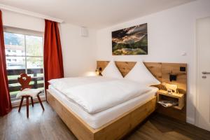 a bedroom with a large bed and a window at Alpin Supreme in Oberstdorf