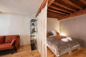 ein Schlafzimmer mit einem Bett und einem Stuhl darin in der Unterkunft Les Paquerettes - Apartment for 3 people in the heart of Annecy in Annecy
