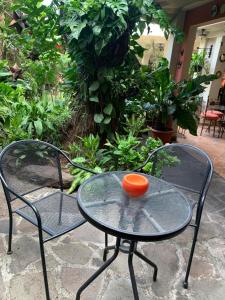 2 Stühle und ein Tisch mit einer orangefarbenen Schüssel darauf in der Unterkunft Hotel La Posada del Angel in San Salvador