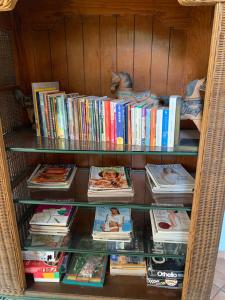 een boekenplank gevuld met boeken en tijdschriften bij Hotel La Posada del Angel in San Salvador
