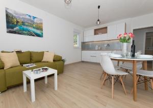 ein Wohnzimmer mit einem grünen Sofa und einem Tisch in der Unterkunft Seaview apartments Oscar in Makarska