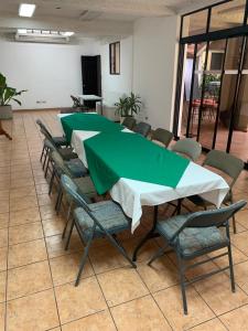 un grupo de mesas y sillas con un mantel verde en Hotel La Posada del Angel, en San Salvador