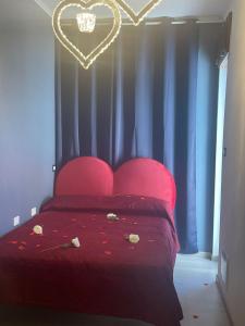 
a bed room with a red bedspread and red curtains at Nidama house in Naples
