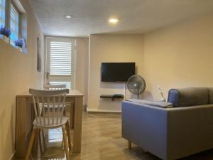 a living room with a couch and a tv at Place2cu-Studio apartment in Willemstad