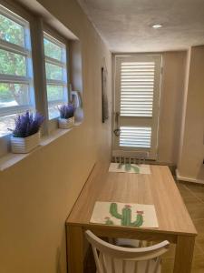 a dining room table with two chairs and a cactus sign on it at Place2cu-Studio apartment in Willemstad