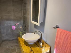 a bathroom with a white sink on a wooden table at Place2cu-Studio apartment in Willemstad