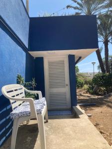 a pair of chairs sitting outside of a blue building at Place2cu-Studio apartment in Willemstad