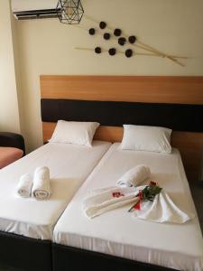 dwa łóżka z ręcznikami i zegar na ścianie w obiekcie Iliana's house w mieście Nausa