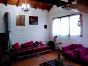 sala de estar con sofá púrpura y ventanas en Luna Llena en Mar del Plata