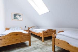 3 letti in legno in una camera con lucernario di Haus am Wald a Niedersalwey