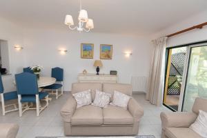 a living room with a couch and a table at Carvoeiro, 2BR Pestana Gramacho Golf Apartment in Estômbar