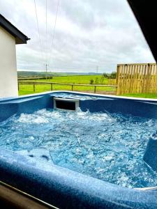 a large blue hot tub with water in it at NEW! Country boutique escape . HOT TUB in Weare Giffard