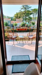 widok na patio z krzesłami i stołami przez okno w obiekcie Luxury apartment - few minutes from the sea w Poreču