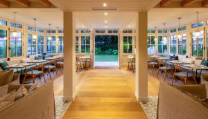 a dining room with tables and chairs and windows at La Villa du Moulleau in Arcachon