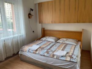 a bedroom with a bed with a wooden headboard and a window at Apartmány Bratislava in Bratislava