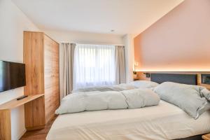 a bedroom with a large bed and a television at Valaisia 125 in Riederalp