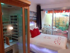 een slaapkamer met een bed met rode kussens en een raam bij Le Bijou Appartement avec Jacuzzi et Sauna privatif Terrasse plein sud Clim Parking Privatif in Bandol