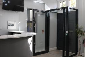 a bathroom with a glass shower and a sink at Blue Sapphire Hotel in Ilford