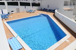 a large swimming pool with chairs in a room at Albufeira Mar Vilas in Albufeira