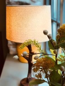 a lamp sitting on a table next to a plant at Little Wren Cartmel Couples Retreat in Cartmel