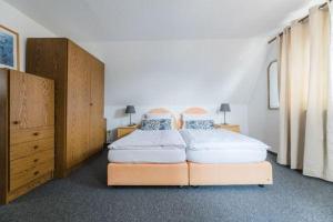 a bedroom with two beds and a dresser at Landhaus Sonnenhang in Niedersalwey