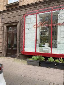 a store front with plants in front of a building at Valentina's Rooms in Vilnius