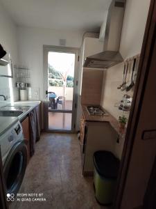 uma cozinha com um fogão e uma porta para um pátio em Les Fonts em Cabacés