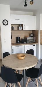 uma cozinha com uma mesa de madeira e cadeiras em Très beau T2 au coeur de la citée thermale em Châtel-Guyon