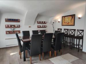 een eetkamer met een tafel en zwarte stoelen bij Relax Lounge in Velké Meziříčí
