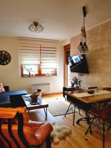 ein Wohnzimmer mit einem Sofa und einem Tisch in der Unterkunft Amber Gold Apartment in Zlatibor