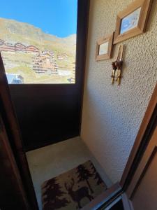 a room with a door with a window and a rug at 2 pièce cabine Val Thorens in Val Thorens