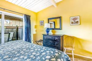 a bedroom with a bed and a dresser and a mirror at Cottage by the Sea in Gearhart
