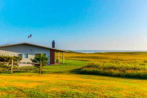 a house in a field next to the ocean at Cottage by the Sea in Gearhart